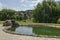 View of public garden with beauty artificial pond and green reflection in residential district, town Delchevo