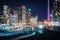 View of railroad tracks and modern buildings in downtown at nigh