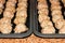 View of raw turkey pine nut meatballs on cookie sheets