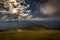 View from Rax plateau, full of fresh, green grassy meadow with blue dramatic cloudy sky to valley and alpine hills