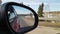 View in the rear view side mirror of a auto, driving a red car