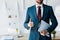 View of recruiter standing and holding clipboard with resume letters while showing thumb up