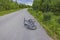 View of recumbent bicycle isolated on asphalt road with forest landscape in background.