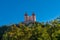 View of the red Calvary Banska Stiavnica under a blue sky with forest in foreground