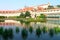 View of reflection in a lake in Wallenstein Garden, its statues and fountain, red tiled roof against vibrant blue sky