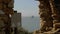 View through the remains of ancient wall, sea tanker at parking