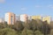 View of the residential area of the city with colored multi storey buildings standing on a hillside overgrown with