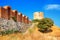 View of the restored wall of the basilica church of the Holy Mother of God Eleusa and windmill ruins in the Old Town of Nessebar