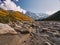 View of the river bottom covered by rocks in the valley under Shkhara glacier in Caucasus mountains, Georgia