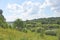 View of the river, forest and green meadows. White clouds in the