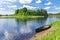 View on river with island and wooden boat laid up on riverbank