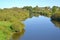 View of the river the Lava with houses on the horizon in summer day. Znamensk, Kaliningrad region