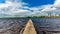 View of the river Shannon with calm waters with a small pier and buildings of Athlone village in the background