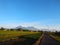 view of the road, rice fields and mountains