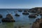 View of the rock formations at the Ponta Joao de Arens, near the Alemao Beach Praia do Alemao on a summer day, with boats and pe