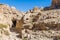 A view of rocks and abandoned dwellings carved into the rock beside the path leading to the ancient city of Petra, Jordan