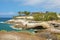 View of the rocky coast and the famous Casa del Duque on cliff in Playa del Duque area in popular resort in southern coast of