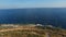 View of the rocky coast near Mamula fortress, seagulls flying over it, and the sea horizon