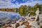 View of the rocky coast shore with the reflection of fall color in the lake