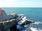 View of the rocky coast. Surf hits the rocks. Summer sunny day