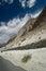 A view of the rocky terrain of the Himalayas with scarce vegetation and a stone wall, Ladakh, India.