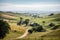 view of rolling hills with farmhouses and crops in the distance