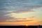 The view from the roof of a high-rise building to the dawn sky, the rising sun and clouds illuminated by the sun.