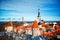 View on the roofs of old town Tallinn, Estonia. Blue sky under red roofs of medieval city with sea on horizon. Sunny day in early