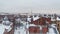 View of the roofs of the winter city. Houses with chimneys in the snow