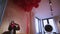 View of room with bouquet of flowers, many red helium air balloons. Little mirror at table. Interior