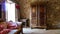 View into room of french cottage built of natural materials in style prevencale with natural stone wall, antique sofa and wooden w