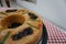 View of a Rosca de Reyes Epiphany Kings Cake on top of a red and white table cloth