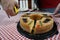 View of a Rosca de Reyes Epiphany Kings Cake on top of a red and white table cloth