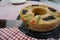 View of a Rosca de Reyes Epiphany Kings Cake on top of a red and white table cloth