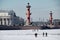 View of the Rosstral Columns - the main attraction of the city, tourists inspect the architecture from the ice of the Neva
