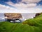 View on rough small island in the ocean from a cliff, Ireland, Kilkee area. Warm sunny day, blue cloudy sky. Travel, tourism and