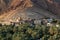 View at ruins of abandoned Birkat al Mawz, Oman, in front of mountain, date palms in front