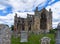 View of the ruins of Melrose Abbey and historic headstones in the church cemetery