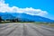 View of the runway of an airport with mountains in the background and clear sky