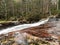 View of rushing water flowing on the river in the forest in Siljan, Norway