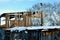 View of rustic wooden hayloft with birdhouse in winter. Abandoned village building.