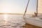 View of the sail boat or yacht floating in sea with relaxed senior man reading a book, sitting on the deck