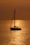 View on the sailboat in the ocean on the sunset in the golden light, close to the beach of Morro Jable on the Canary Island