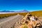 View of Salar de Uyuni with the dormant volcano and a dirty road