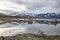 View of a Saline Soda Lake with Snow Capped Eastern Sierra Navada Mountains on a Cloudy Day in the Afternoon with Sunlight Shinnin