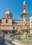 View of San Giuseppe dei Teatini church dome with statue of the Pretoria fountain ahead in Palermo, Sicily.