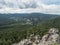 View from sandstone rock viewpoint Monchskanzeland on spruce tree forest, village Oybin and Zittauer Gebirge mountains