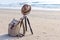 View of the sandy beach with a brown hat and knapsack on the beach near the sea.