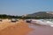 View on a sandy beach near to sea and fishing village with a lot of garbage. Pollution of a coastline.