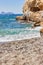 View of sandy beach, sealine, waves, cliff and blue sky in the summer sunny day